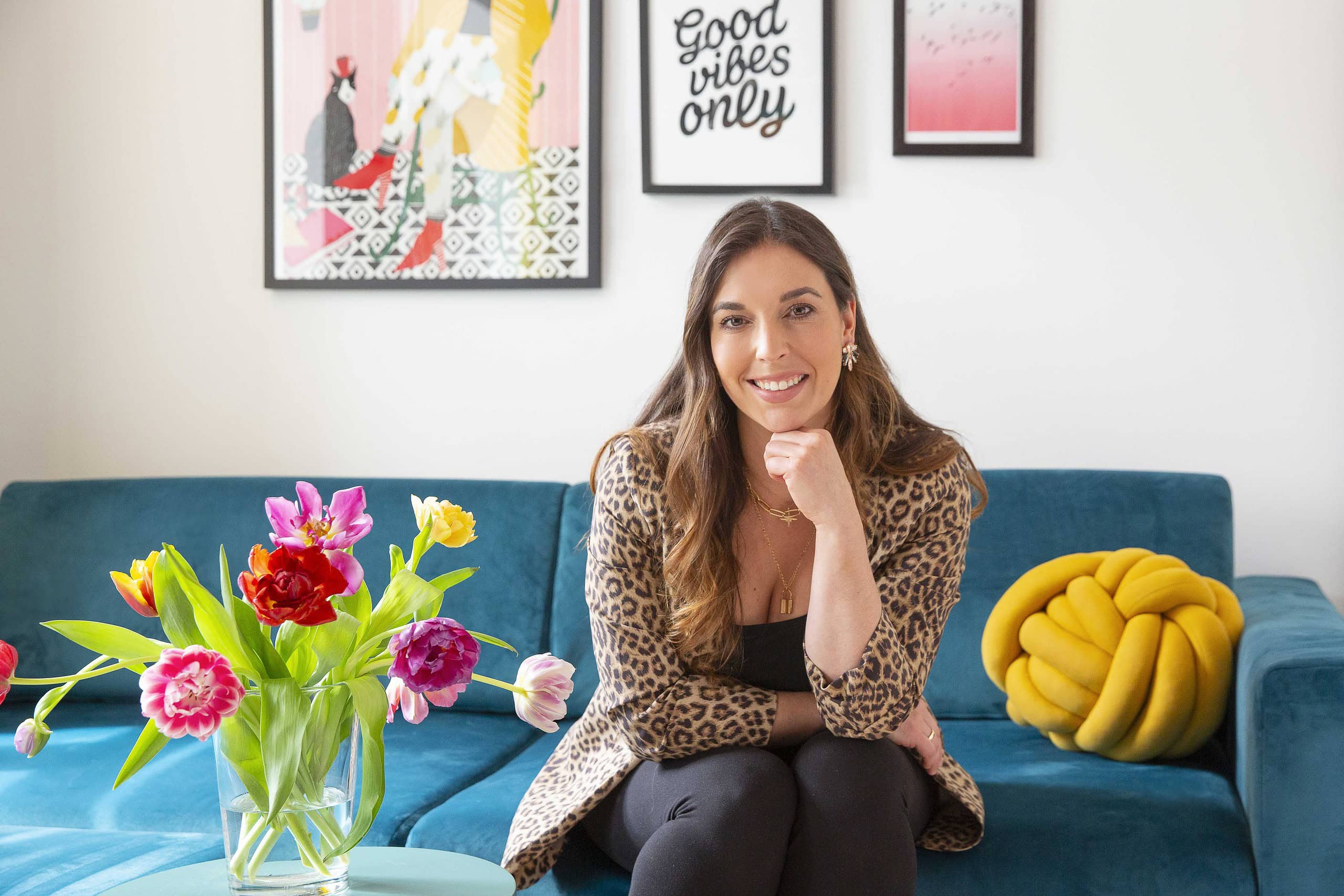 Portrait Pauline Lajehanniere Appel von VISUAL BUHO auf Sofa mit Bildern im Hintergrund